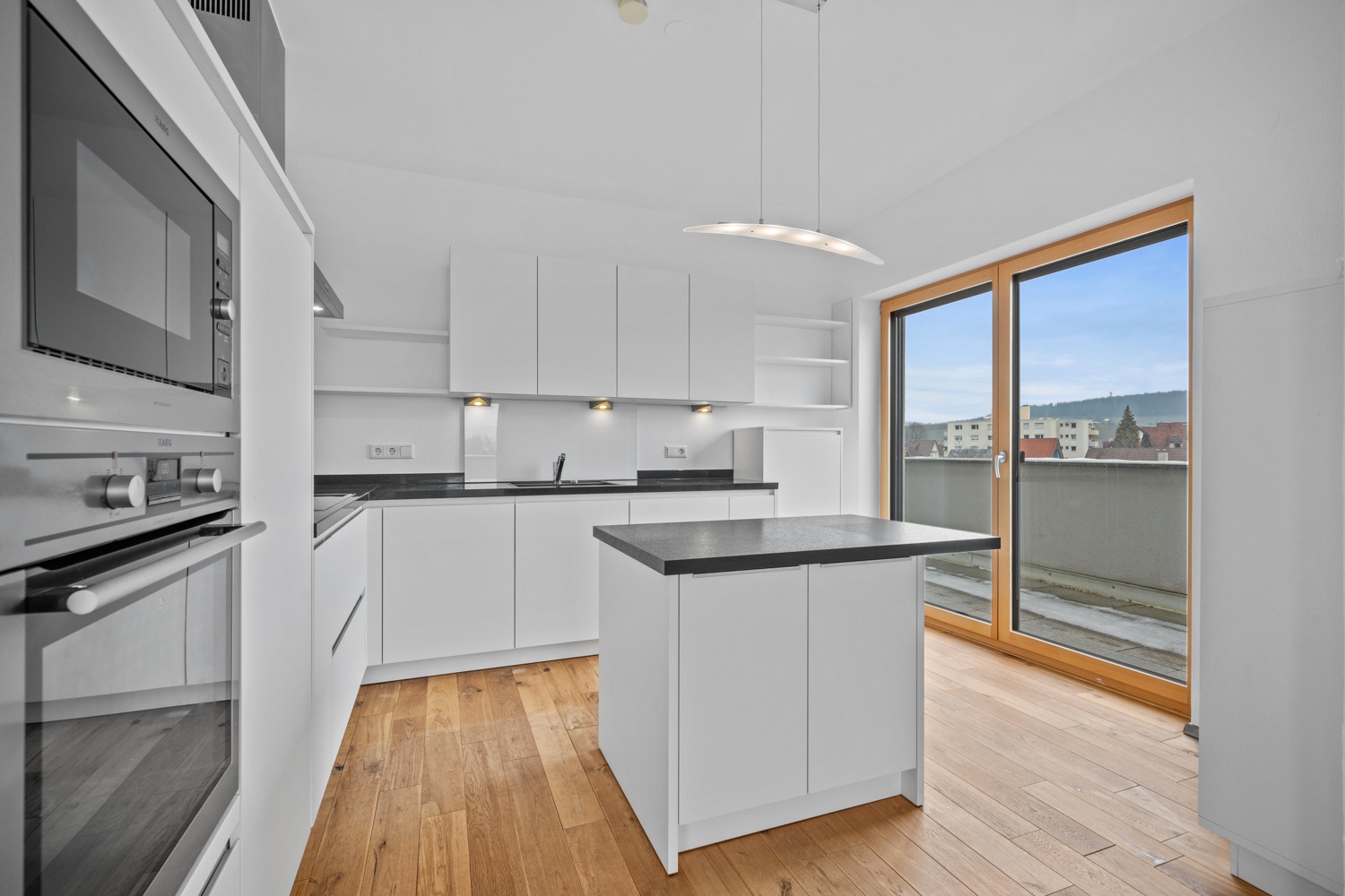 Moderne Wohnküche mit Kochinsel und hochwertigen Elektrogeräten